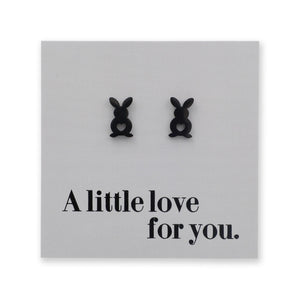 Black bunny-shaped earrings on a gray card with 'A little love for you.' text