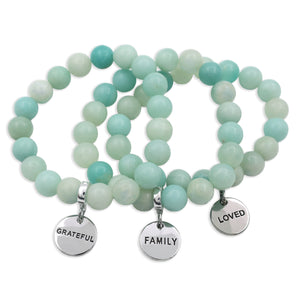 Set of mint teal amazonite stone beaded bracelets with silver charms on a white background