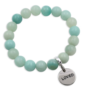 Turquoise beaded bracelet with a silver 'LOVED' charm on a white background