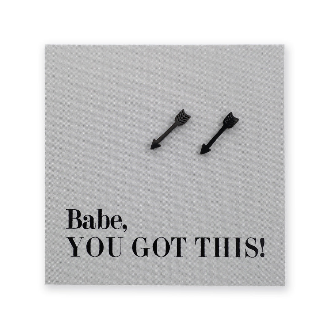 A square gray card or plaque with the text 'Babe, YOU GOT THIS!' in black serif font, with two small black arrowhead studs near the top center, shown on a white background.