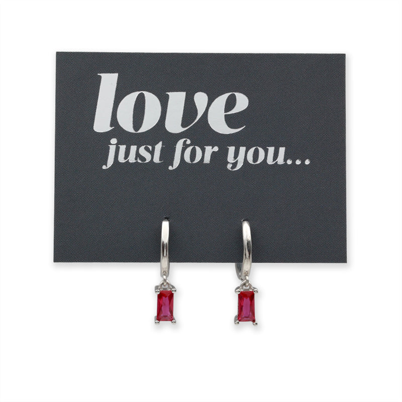 A pair of silver hoop earrings with rectangular red gemstones, displayed on a black card that reads 'love just for you...'.