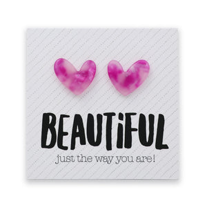 A pair of pink and purple marbled heart-shaped stud earrings displayed on a white textured square card with the text 'BEAUTIFUL just the way you are!'.