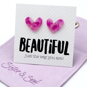 Pink marbled heart-shaped stud earrings displayed on a white card that reads 'BEAUTIFUL just the way you are!' resting on a lavender fabric pouch with ' Sister & Soul'.