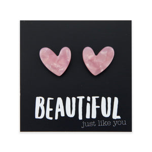 Heart-shaped pink earrings on a black card with 'BEAUTiFUL just like you' text.