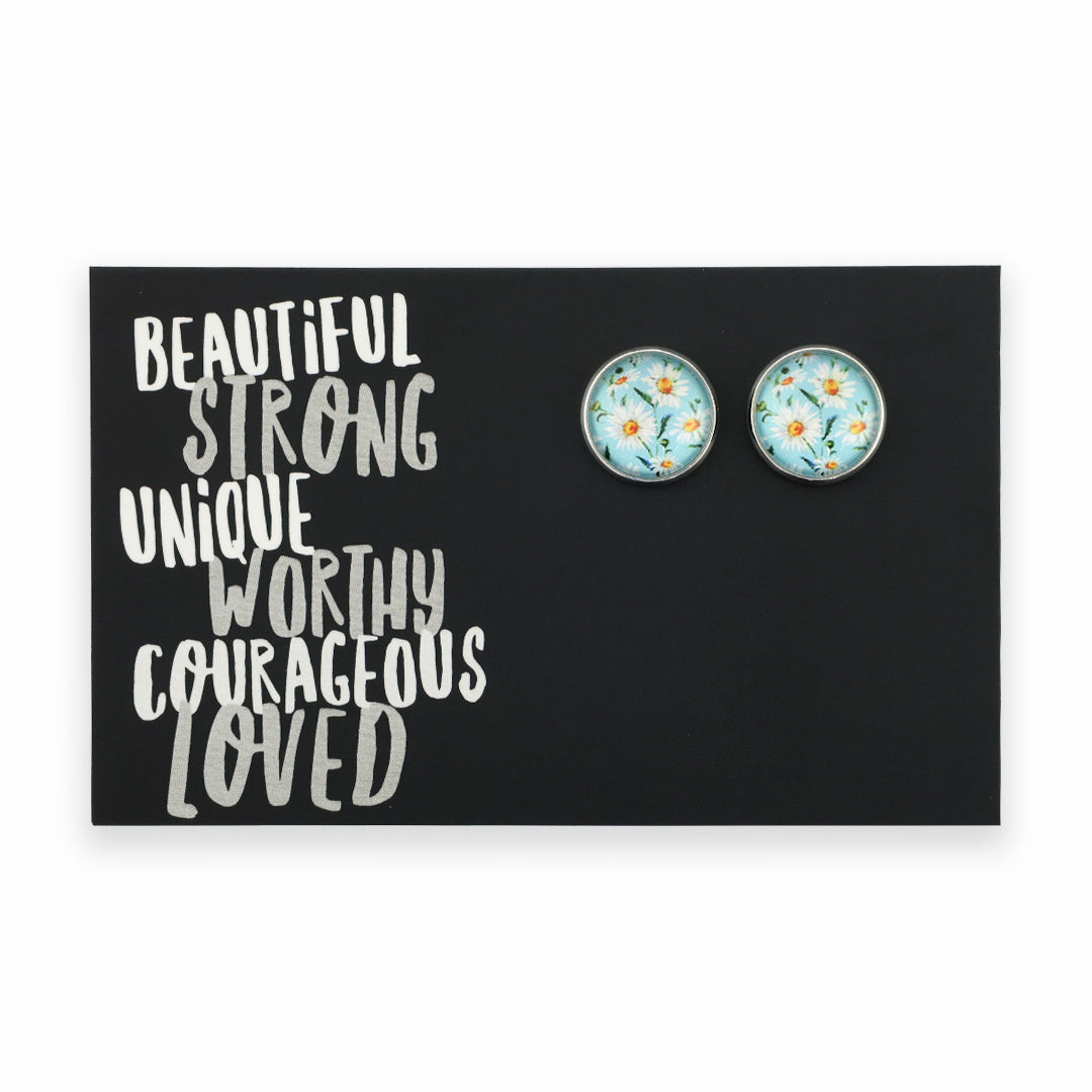 Pair of round earrings with floral design on a black card with motivational text