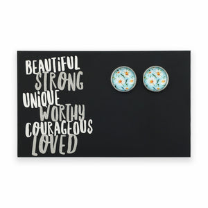 Pair of round earrings with floral design on a black card with motivational text