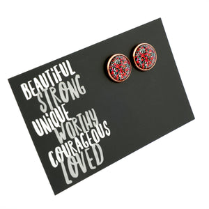 Round earrings with floral design on a black card with motivational text