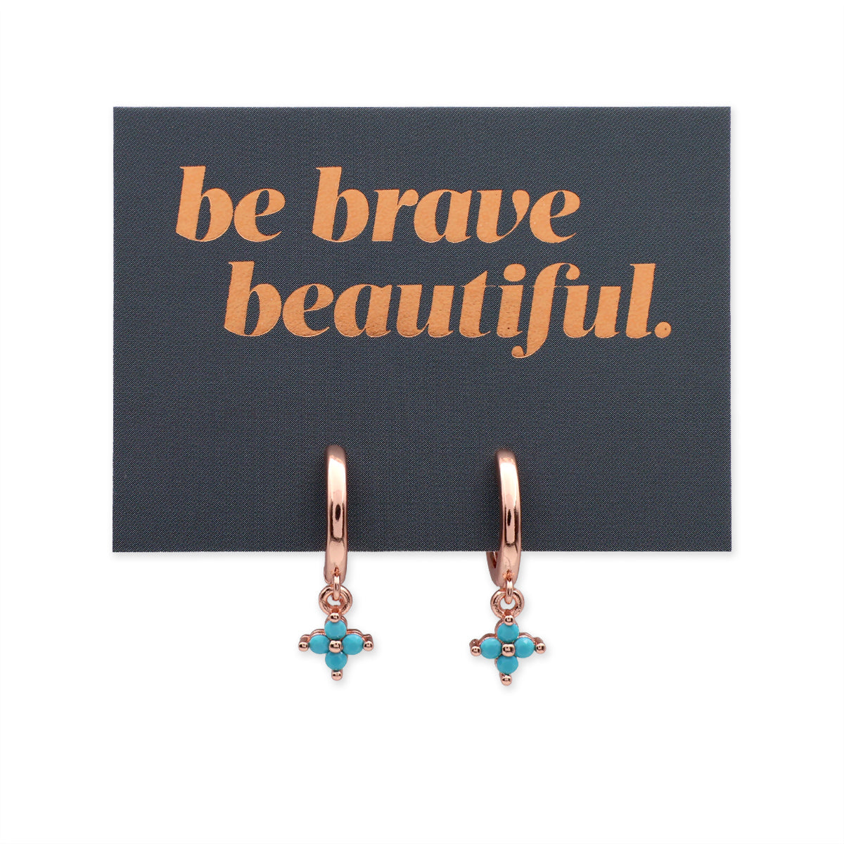 Rose gold earrings with turquoise stones on a card with 'be brave beautiful' text.