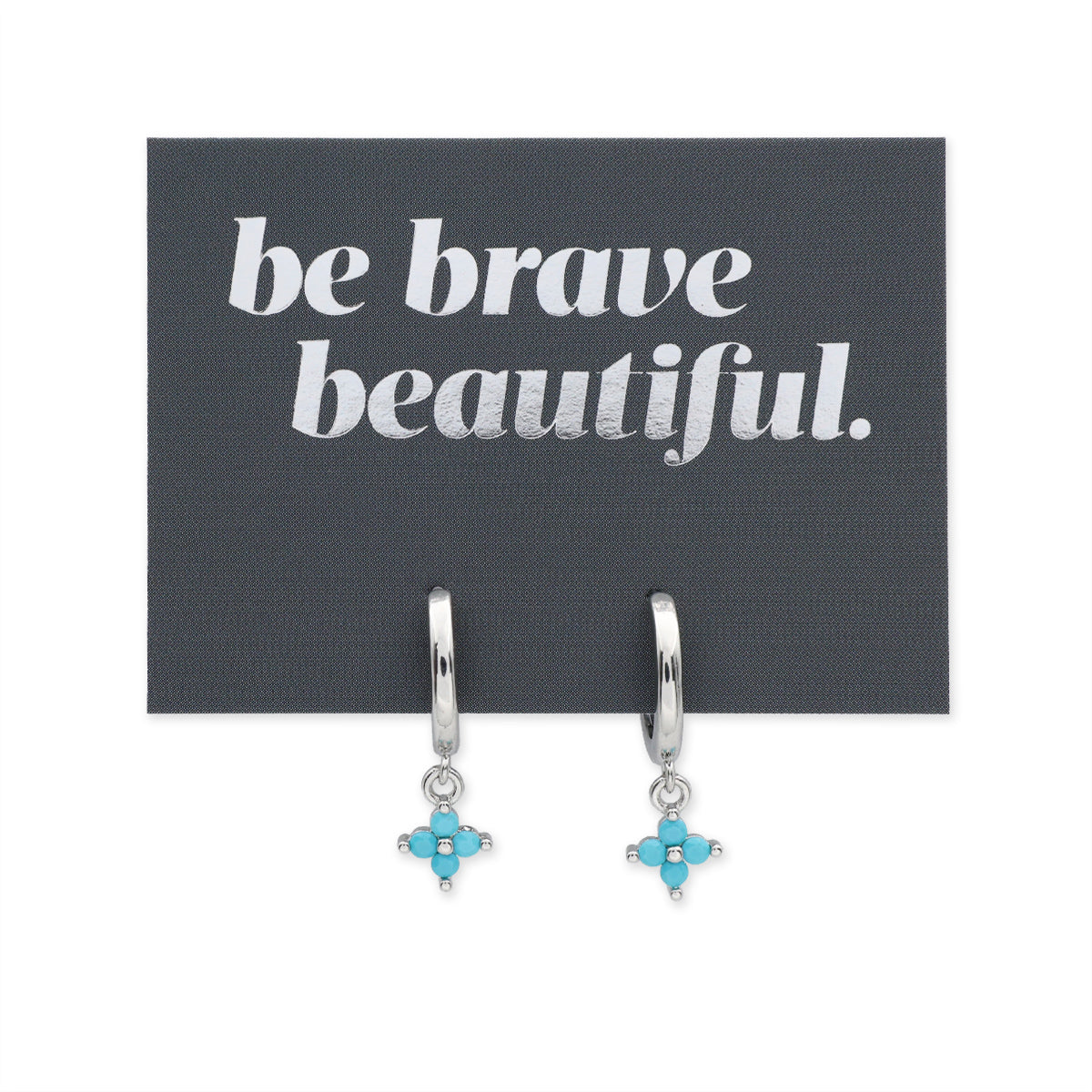 Silver earrings with turquoise stones on a card with 'be brave beautiful' text.