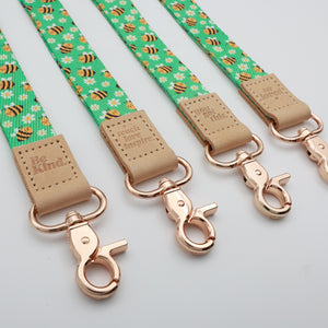 Bees lanyards showing Be Kind, Teach Love Inspire, You Got This and So Loved embossed trims and lobster clasps.