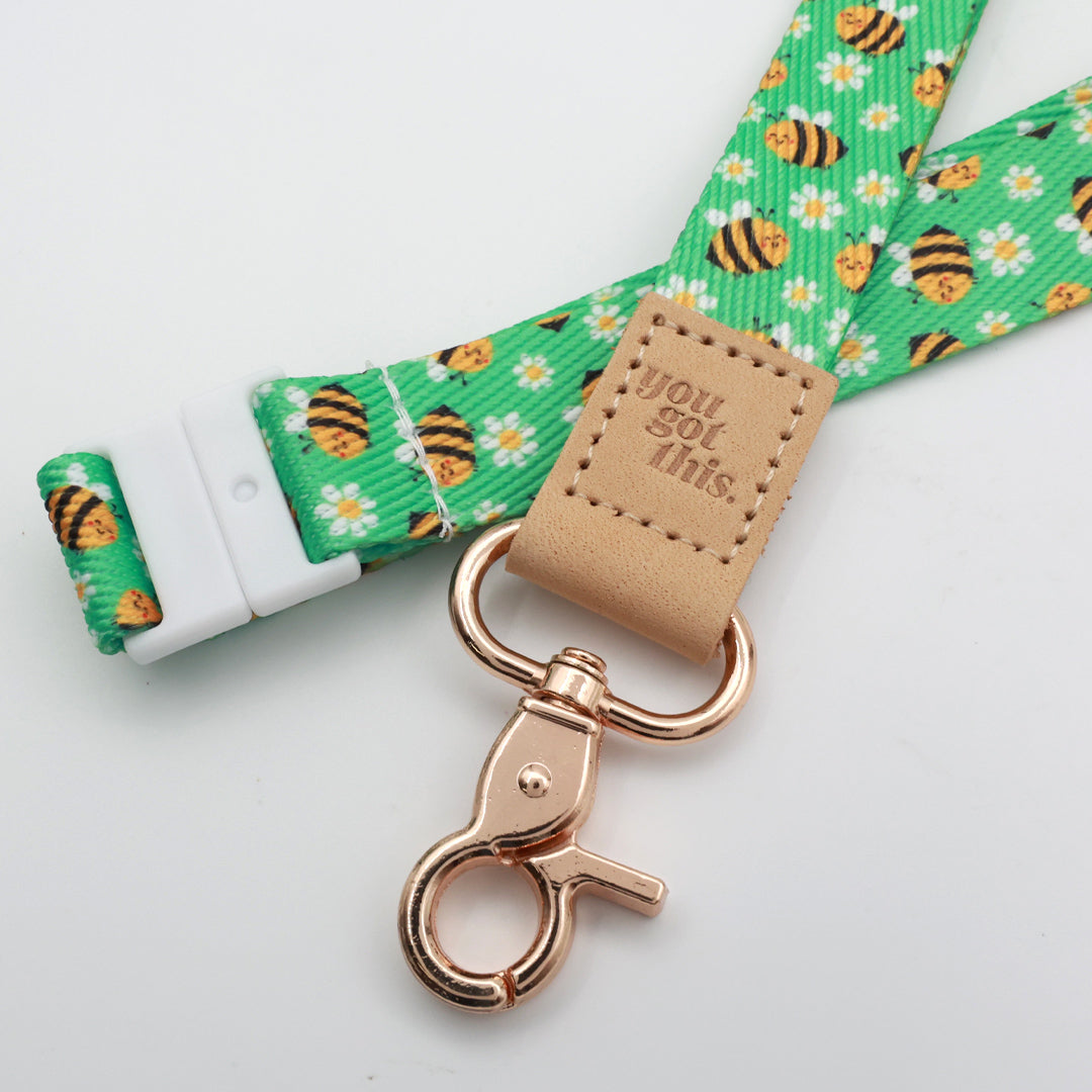 You Got This embossed on a green bee and daisy lanyard with tan trim and a lobster clasp.