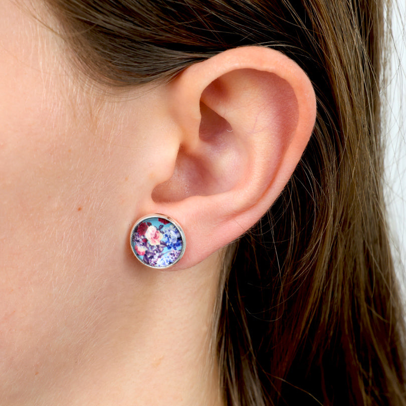 Close-up of an ear wearing a colorful round earring.