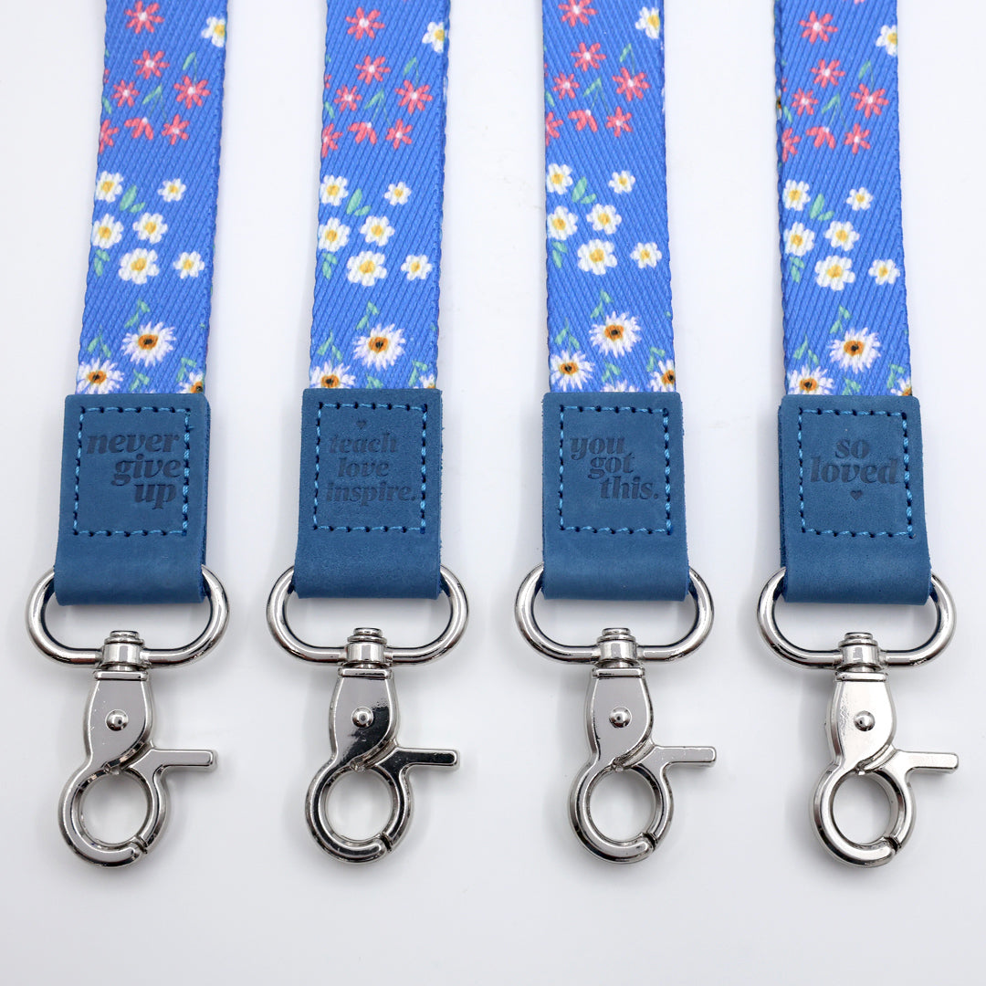 Set of blue floral lanyards with metal hooks on a white background