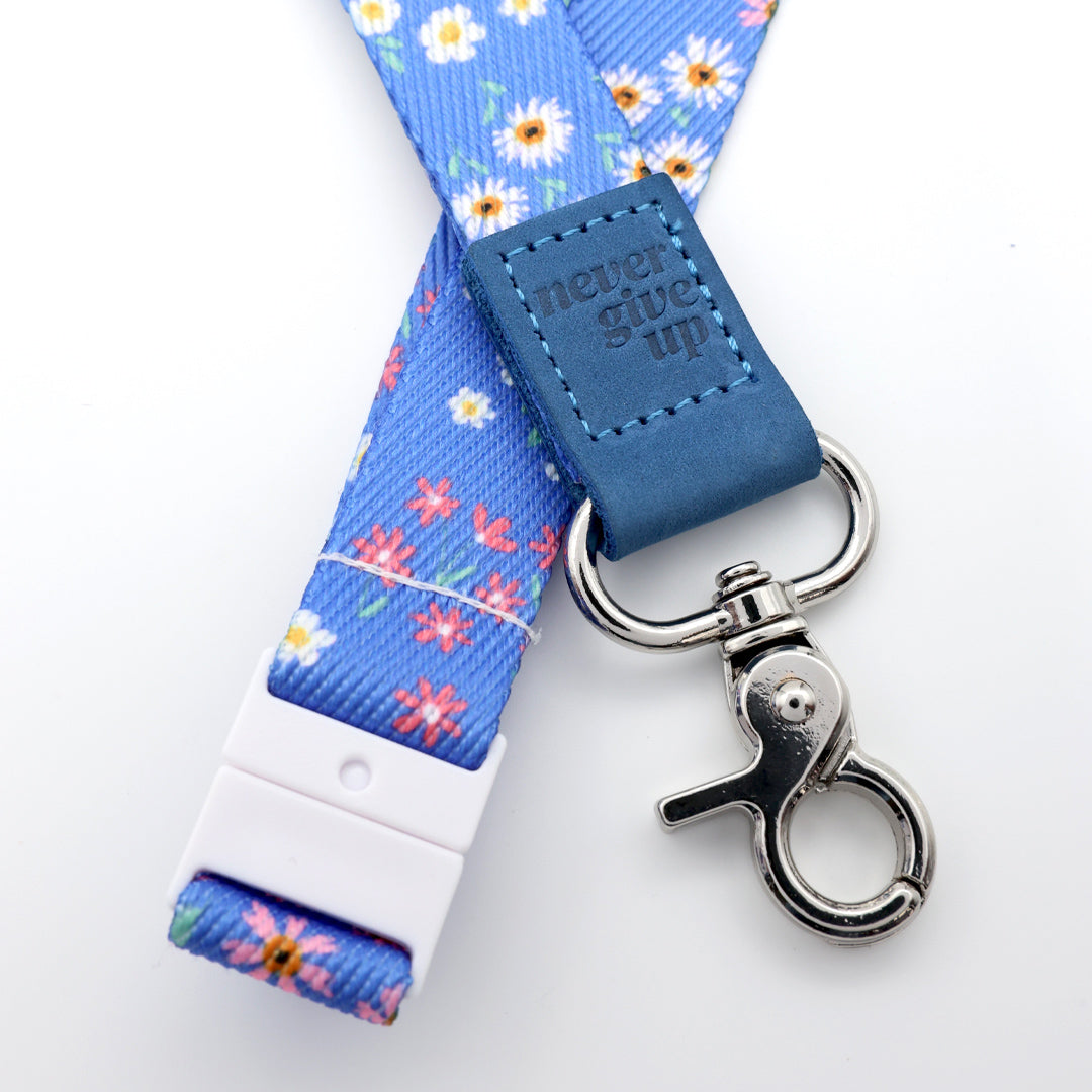 Floral lanyard with blue accent and 'never give up' tag on a white background