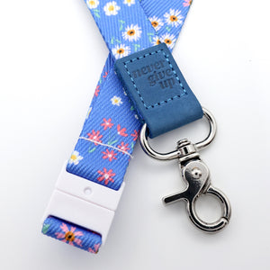 Floral lanyard with blue accent and 'never give up' tag on a white background