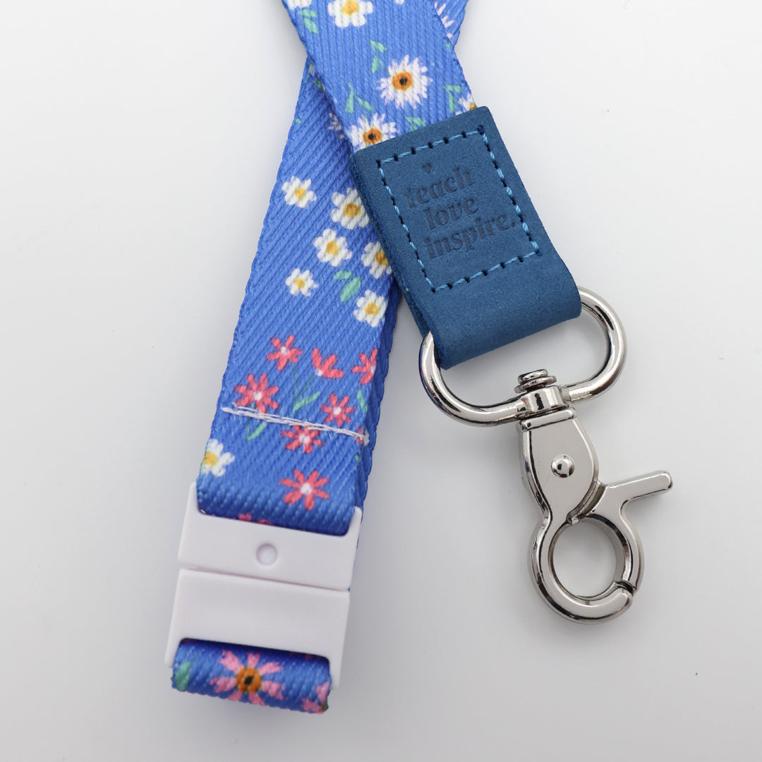 Blue floral lanyard with a metal clip on a white background
