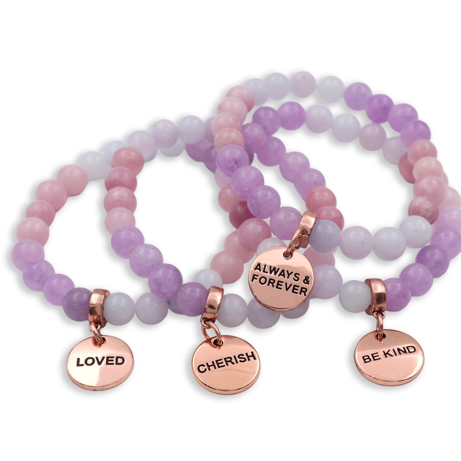 Set of beaded bracelets with rose gold charms on a white background
