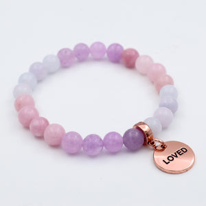 Beaded bracelet with a 'LOVED' charm on a white background