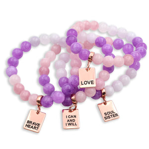 Set of beaded bracelets with inspirational charms on a white background