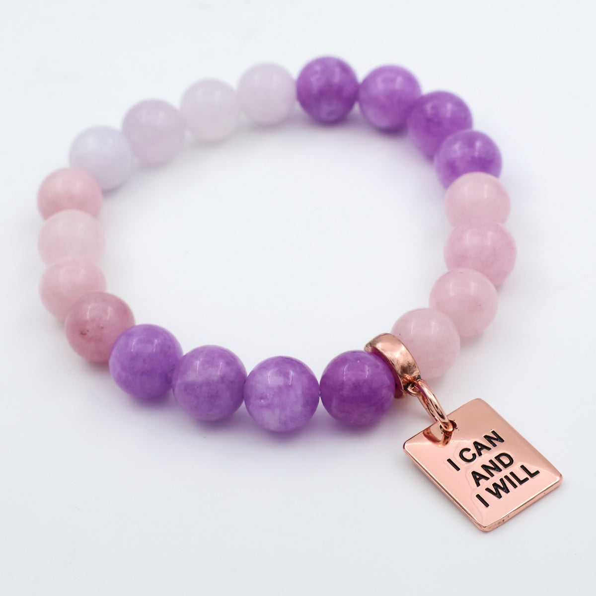 Purple and pink beaded bracelet with a rose gold tag on a white background