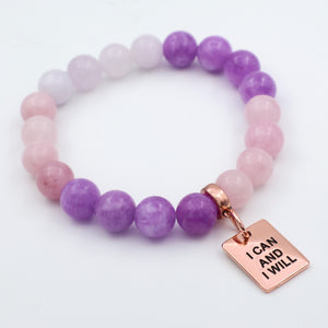 Purple and pink beaded bracelet with a rose gold tag on a white background