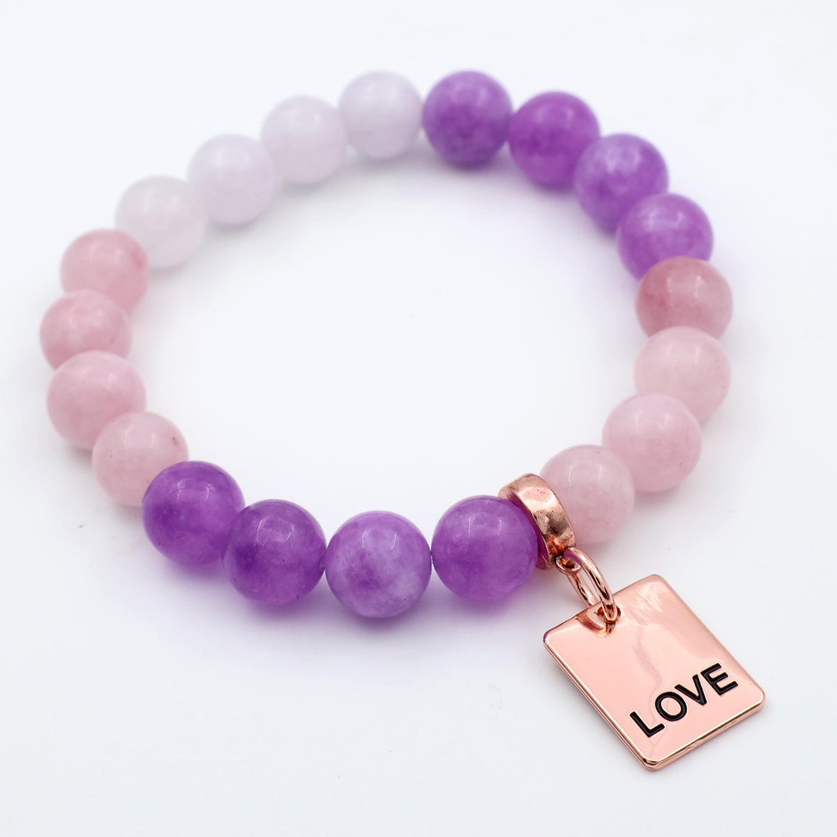 Bracelet with purple and pink beads and a 'LOVE' tag on a white background