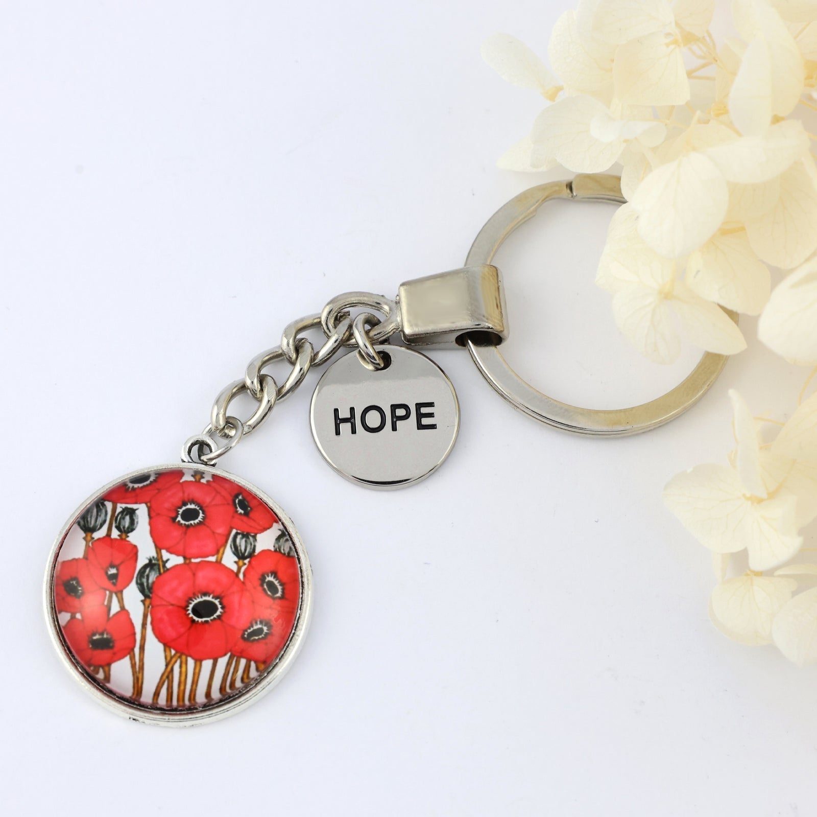 Keychain with red poppy design and 'HOPE' tag on a white background