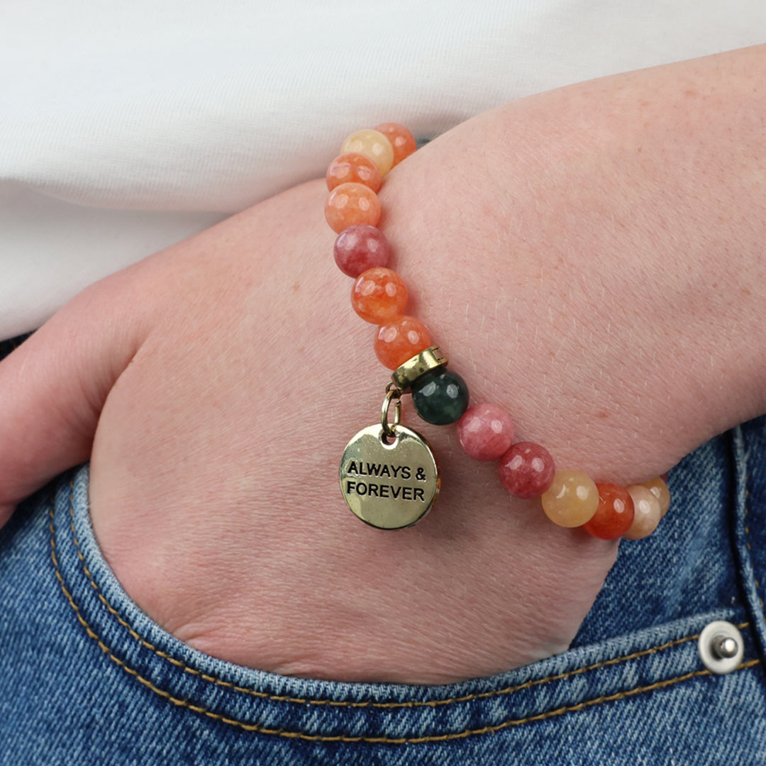 Beaded bracelet with 'Always & Forever' charm on a wrist, worn with jeans.
