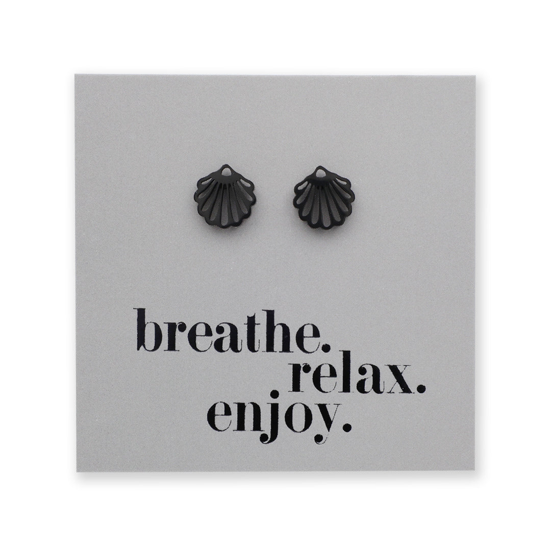 Black shell-shaped earrings on a gray card with 'breathe. relax. enjoy.' text