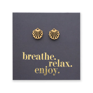 Gold shell earrings on a dark gray card with 'breathe. relax. enjoy.' text.