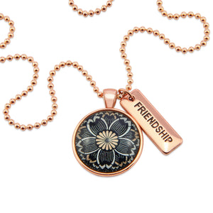 Necklace with floral pendant and 'FRIENDSHIP' tag on a white background