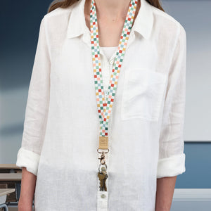 Person wearing a white shirt with a colorful lanyard around their neck.