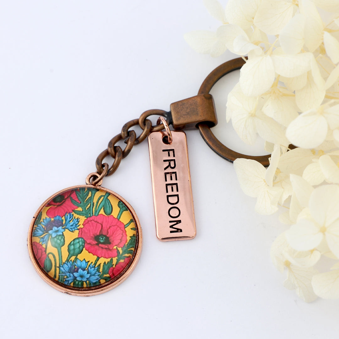 Keychain with floral design and 'freedom' tag on a white background