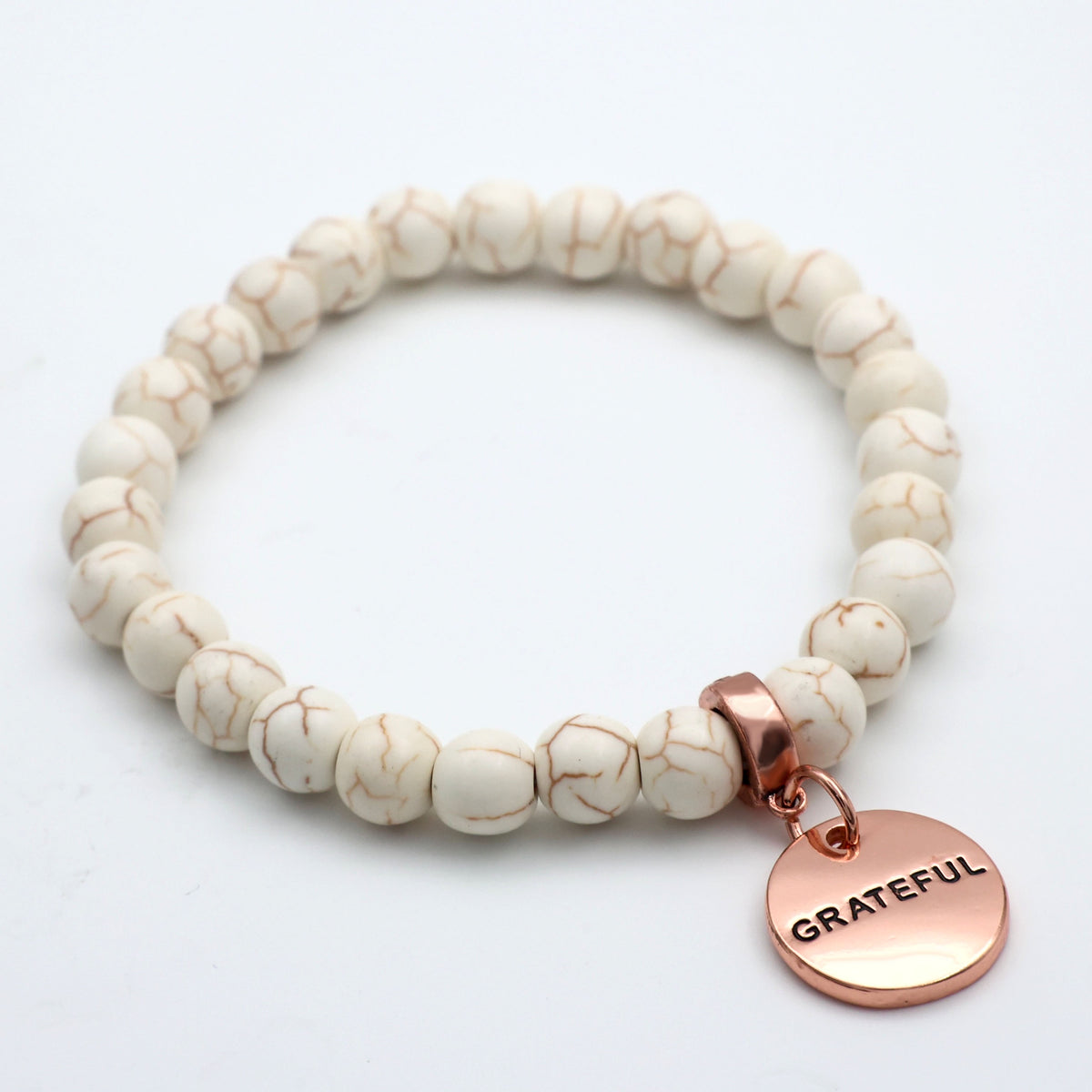 Beaded bracelet with a 'GRATEFUL' charm on a white background