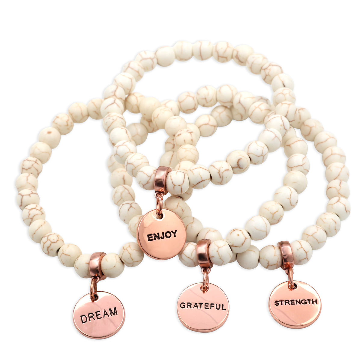 Set of white beaded bracelets with rose gold charms on a white background