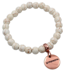 Beaded bracelet with a 'STRENGTH' charm on a white background