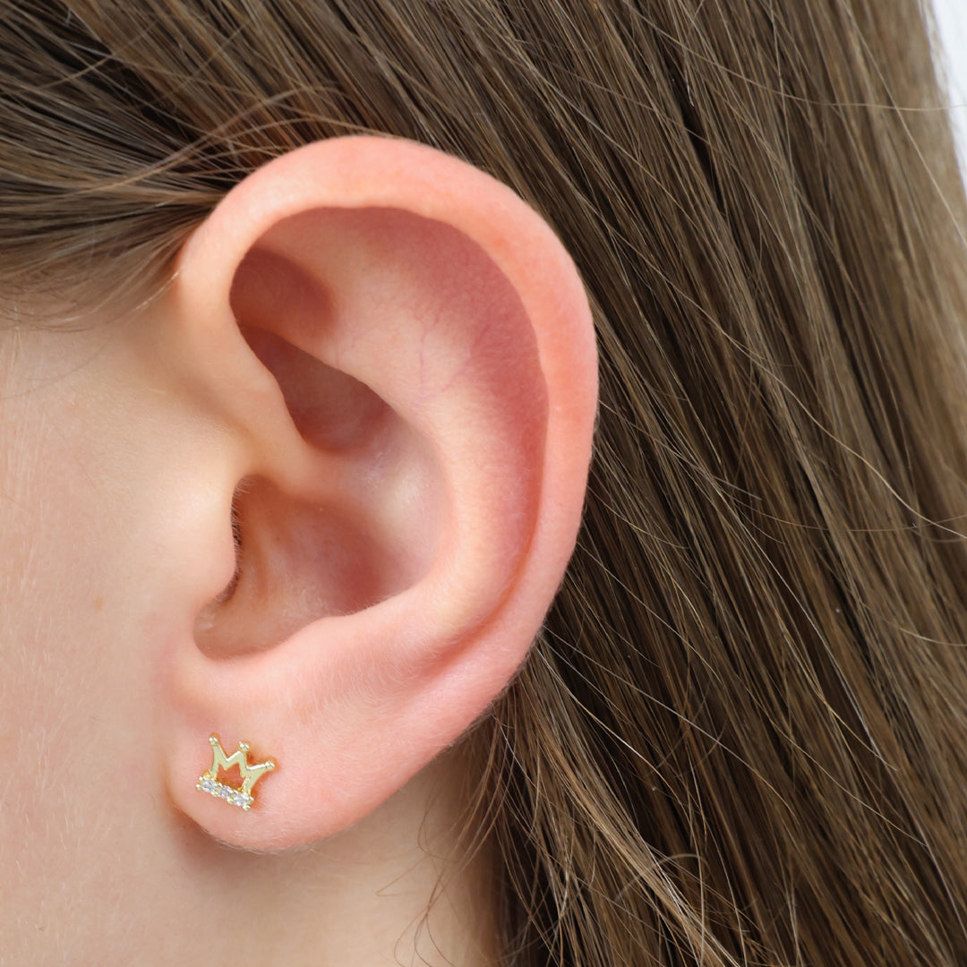 Close-up of an ear wearing a star-shaped earring with brown hair.