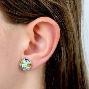 Close-up of an ear wearing a colorful floral stud earring.