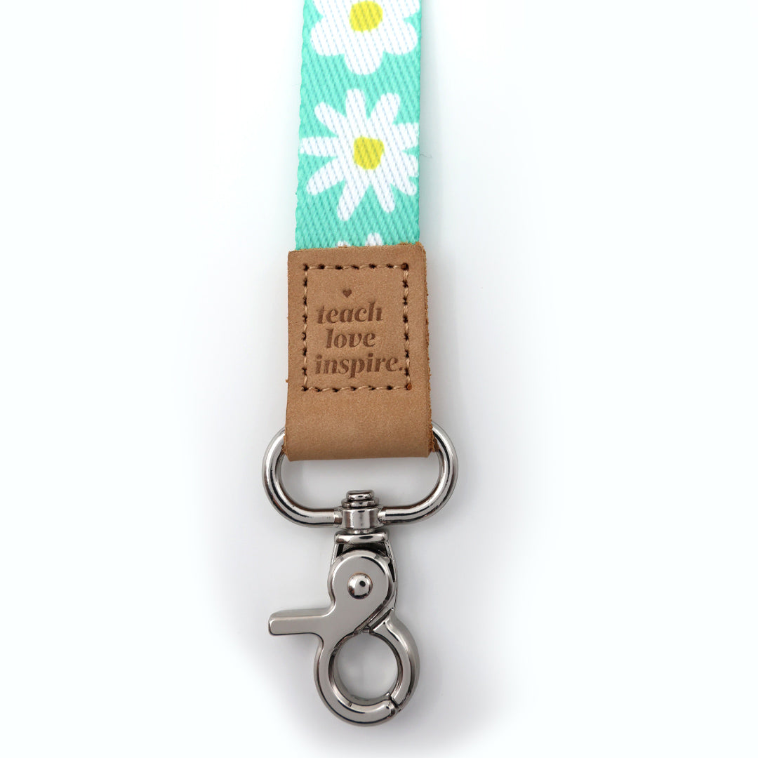 Leash with daisy pattern and 'teach love inspire' tag on a white background