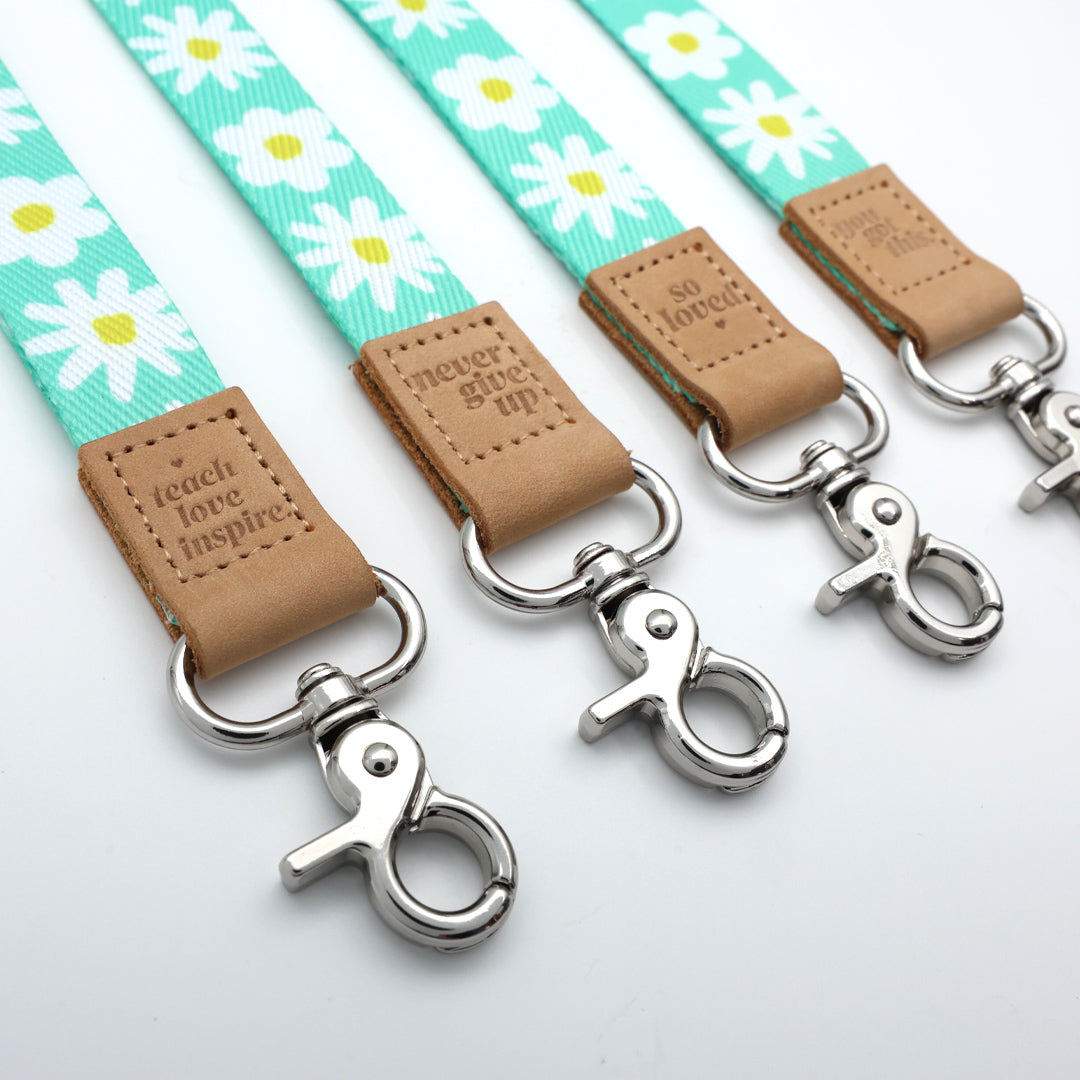 Dog leashes with daisy pattern and leather ends on a white background