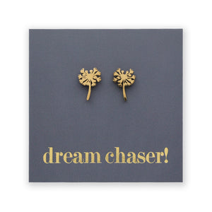 Gold dandelion-shaped earrings on a blue card with 'dream chaser!' text.