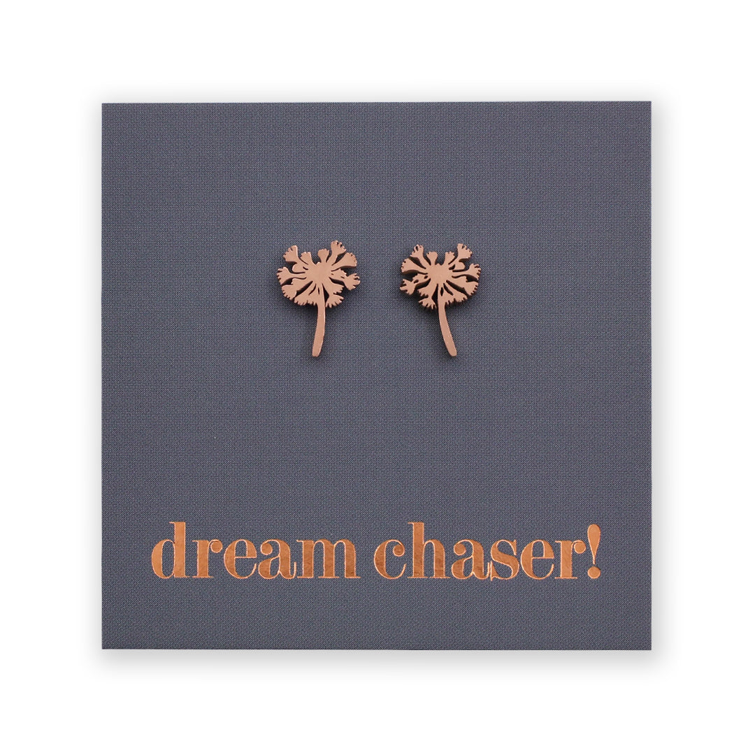Copper dandelion-shaped earrings on a dark gray card with 'dream chaser!' text.