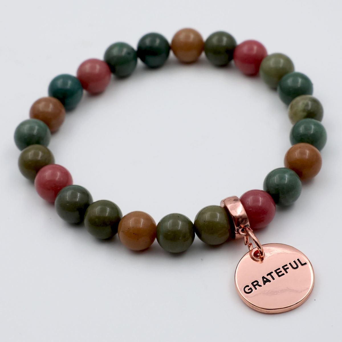 Multicolored beaded bracelet with a 'GRATEFUL' charm on a white background