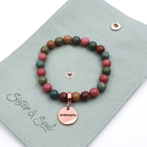 Beaded bracelet with a 'Strength' charm on a 'Sister & Soul' branded card.