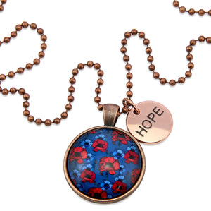 Necklace with floral pendant and 'HOPE' tag on a white background