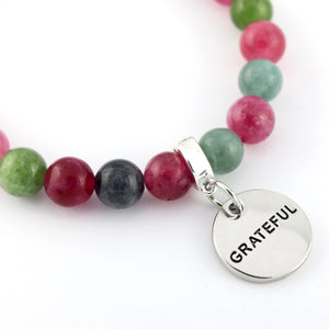 Bracelet with multicolored beads and a 'GRATEFUL' charm on a white background