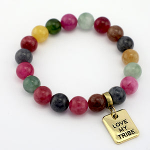 Multicolored beaded bracelet with a gold 'Love My Tribe' charm on a white background