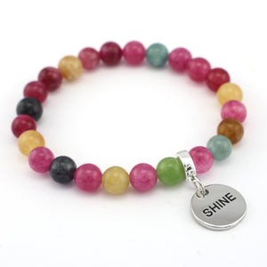 Multicolored beaded bracelet with a silver 'SHINE' charm on a white background