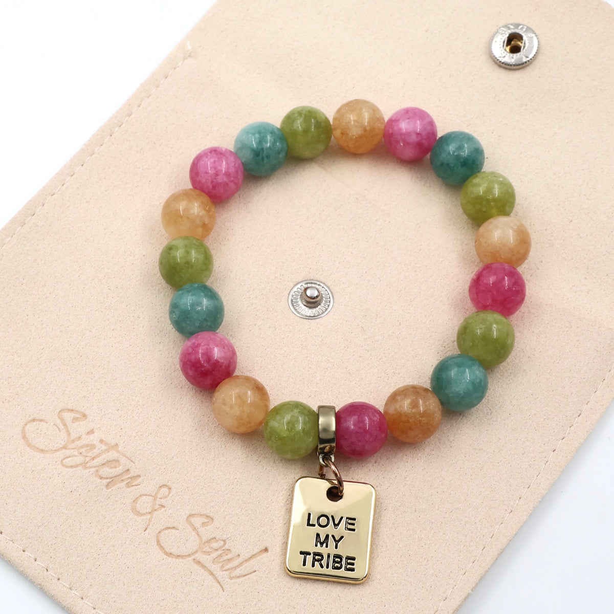 Colorful beaded bracelet with 'Love My Tribe' charm on a beige card, featuring the brand 'Sister & Soul'.