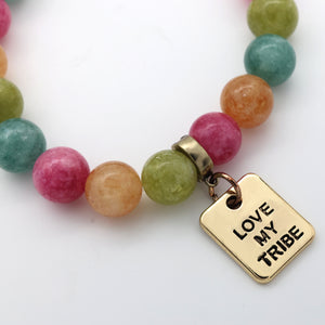 Colorful beaded bracelet with a gold 'Love My Tribe' charm on a white background